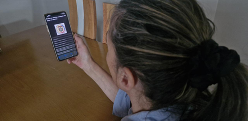 Mujer viendo el teléfono con una citación judicial falsa
