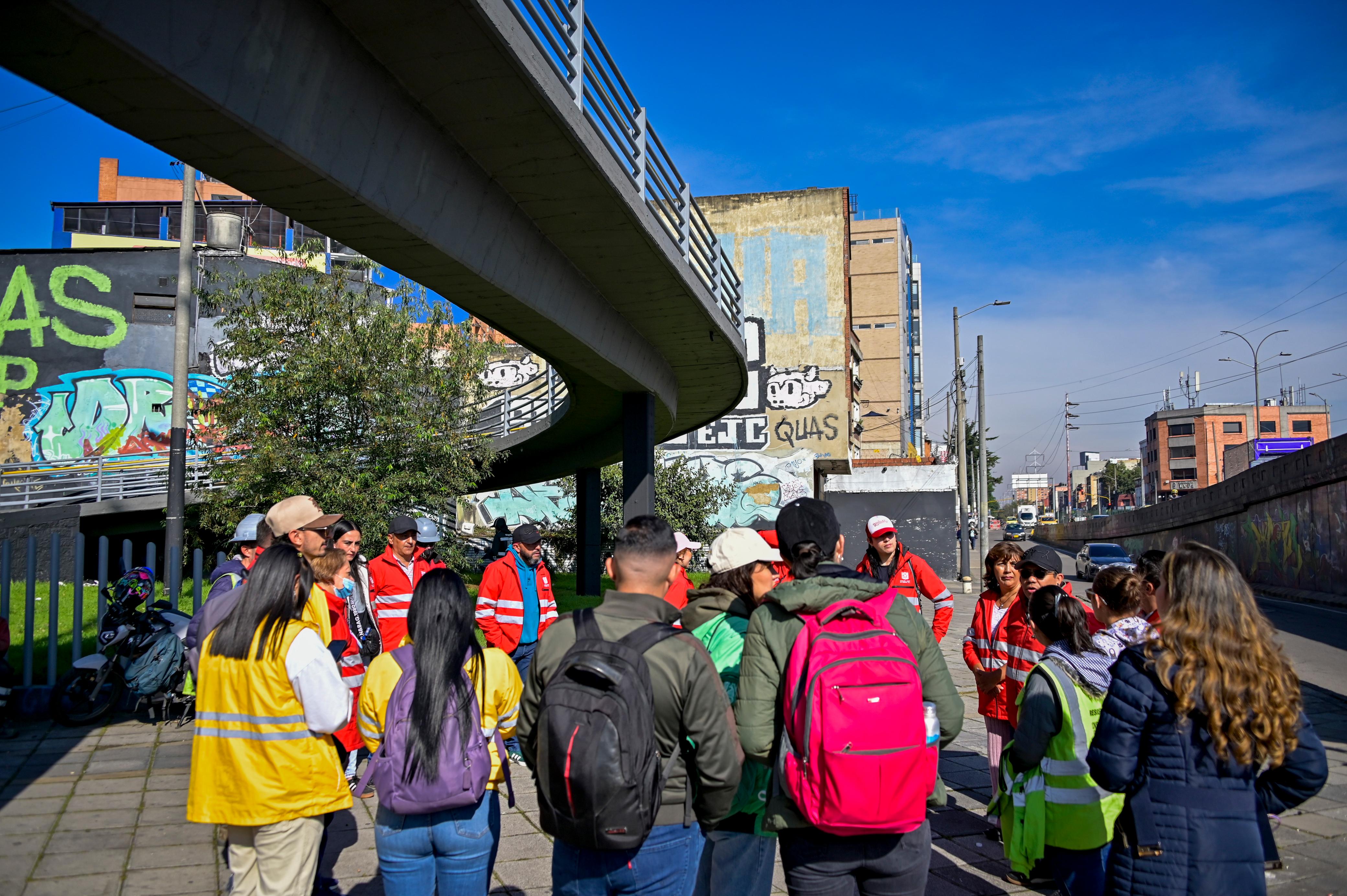 Varias personas en la calle cerca a un puente