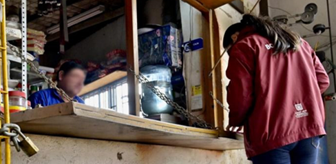 Mujer Gestora del Orden hablando con un señor en una tienda
