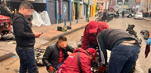 Hombres revisando motores incautados junto a gestores del orden