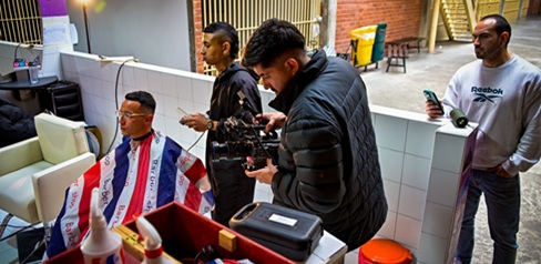 Cuatro hombres dentro de una barbería grabando un video