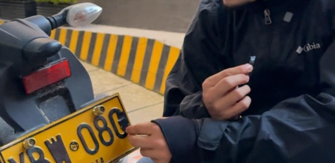 Hombre adulterando la placa de una moto