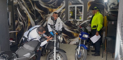 Cuatro hombres revisando dos motos