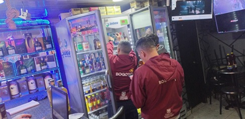 Varios hombres en establecimiento de comercio de licor