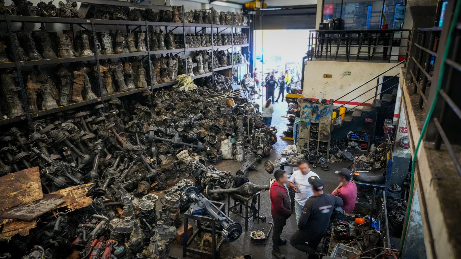Cuatro hombres en una bodega de autopartes