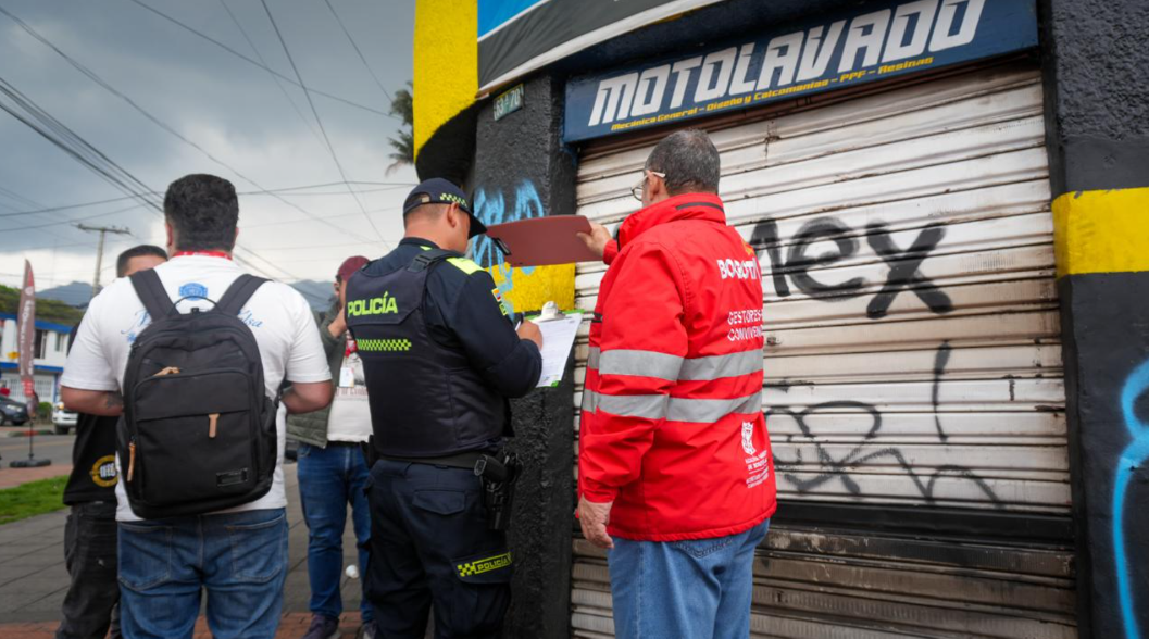 Operativo contra el hurto de vehículos dejó cierres de establecimientos y sanciones en Barrios Unidos Policía y funcionario de la alcaldía sellando establecimiento comercial