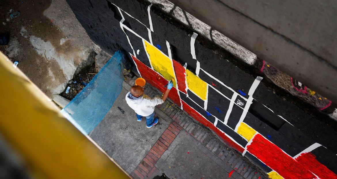 Del comparendo al mural: colados y demás infractores embellecieron puente de la calle 72 con 68 para saldar su deuda con Bogotá Un hombre pintando un puente