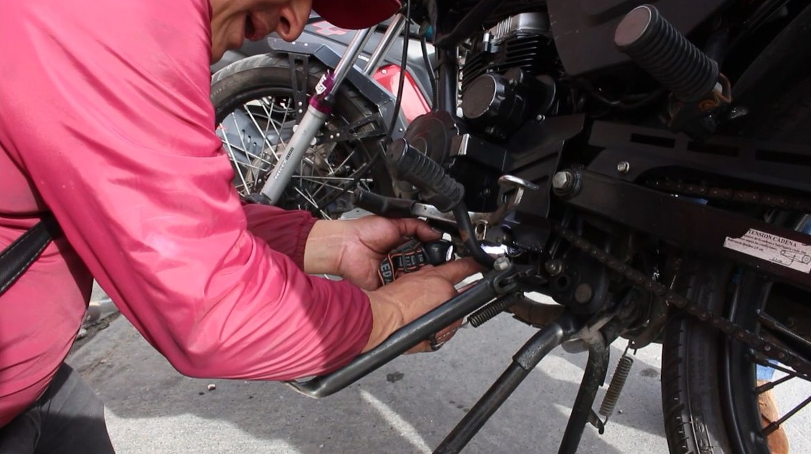 Hombre revisando motocicleta
