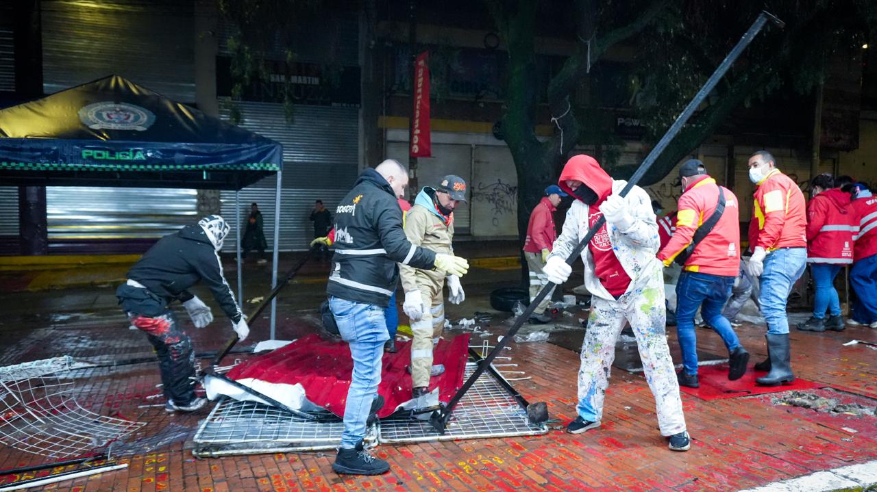 Hombres desmontando unas rejas en la calle