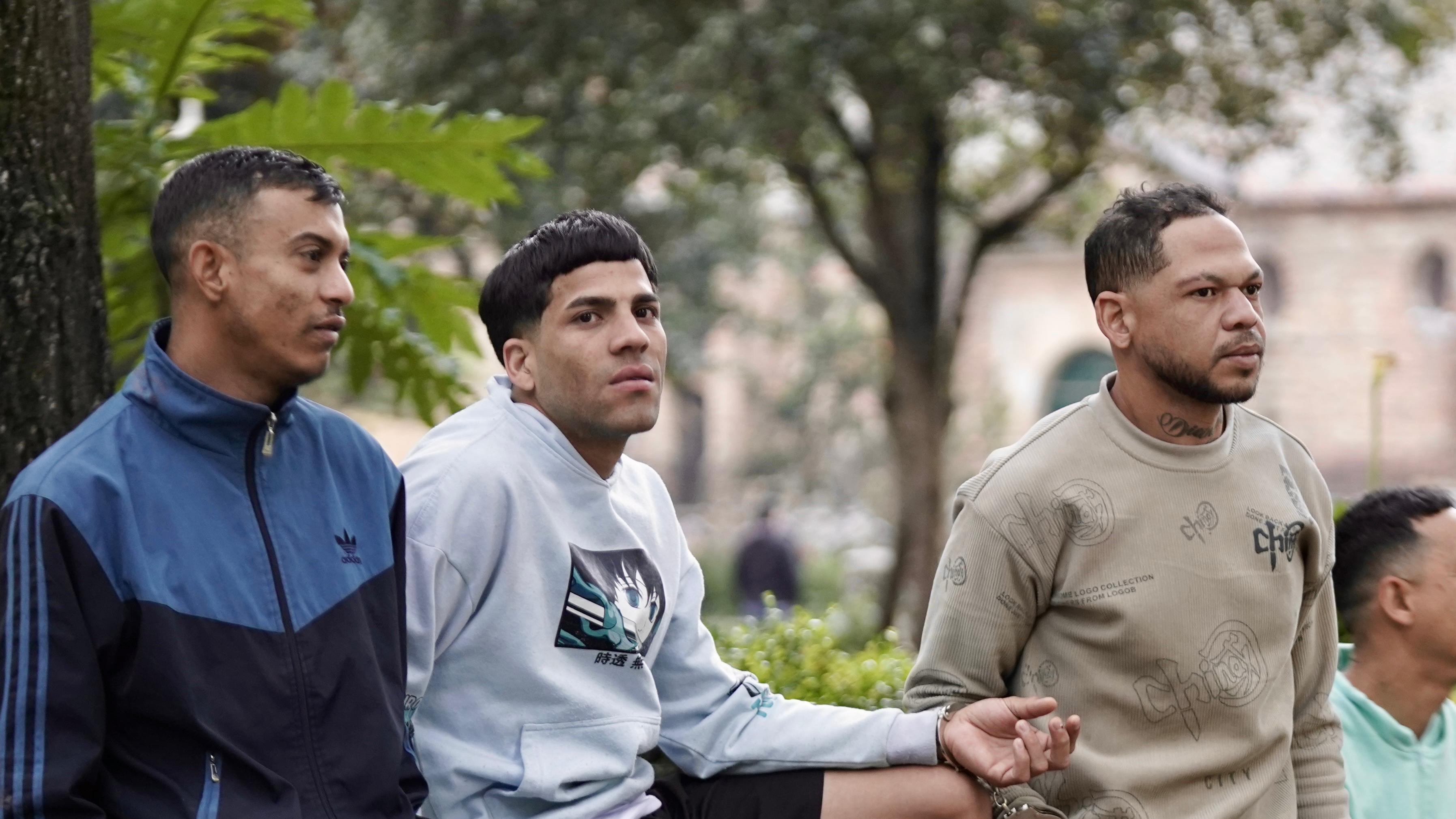 Cuatro hombres esposados entre si