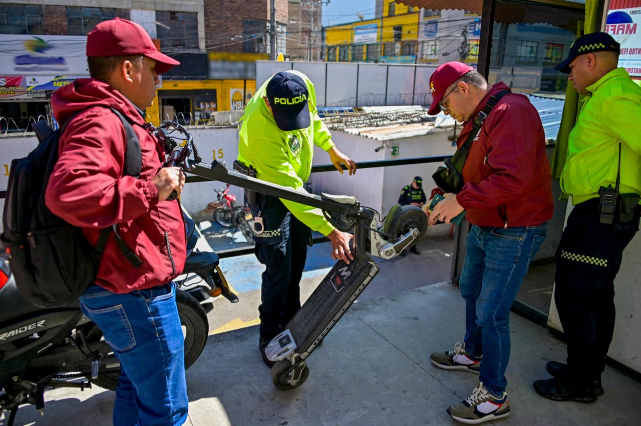 Funcionarios de la alcaldía y policías revisando patinetas