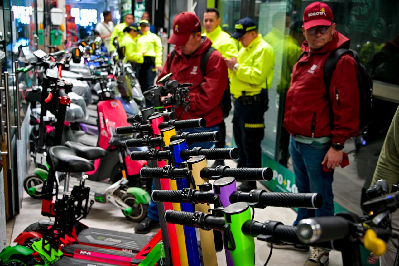Funcionarios de la alcaldía y policías revisando patinetas