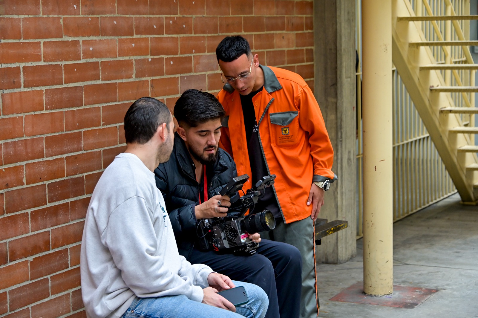 Tres hombres revisando una cámara de video