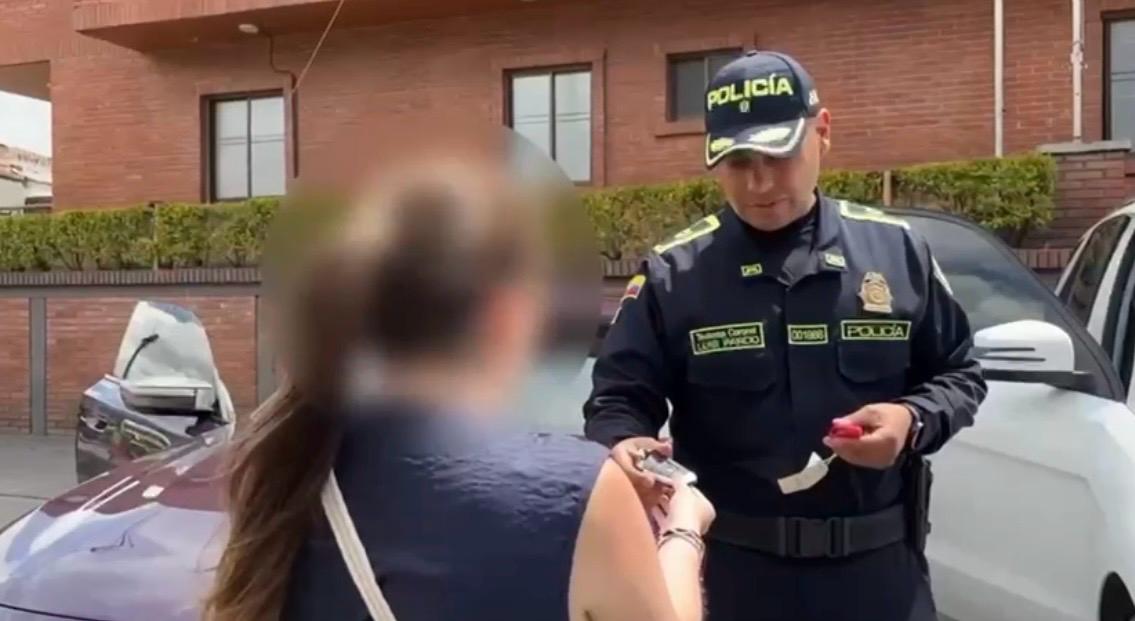 Policía entregando las llaves de un carro a una mujer