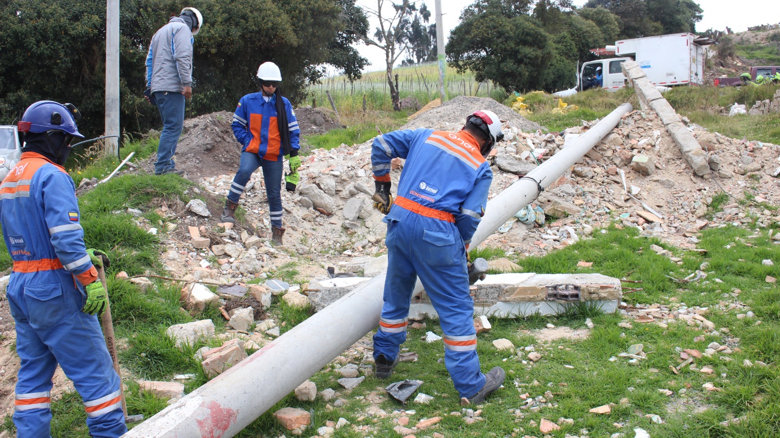 Cuatro hombres quitando un poste de la luz