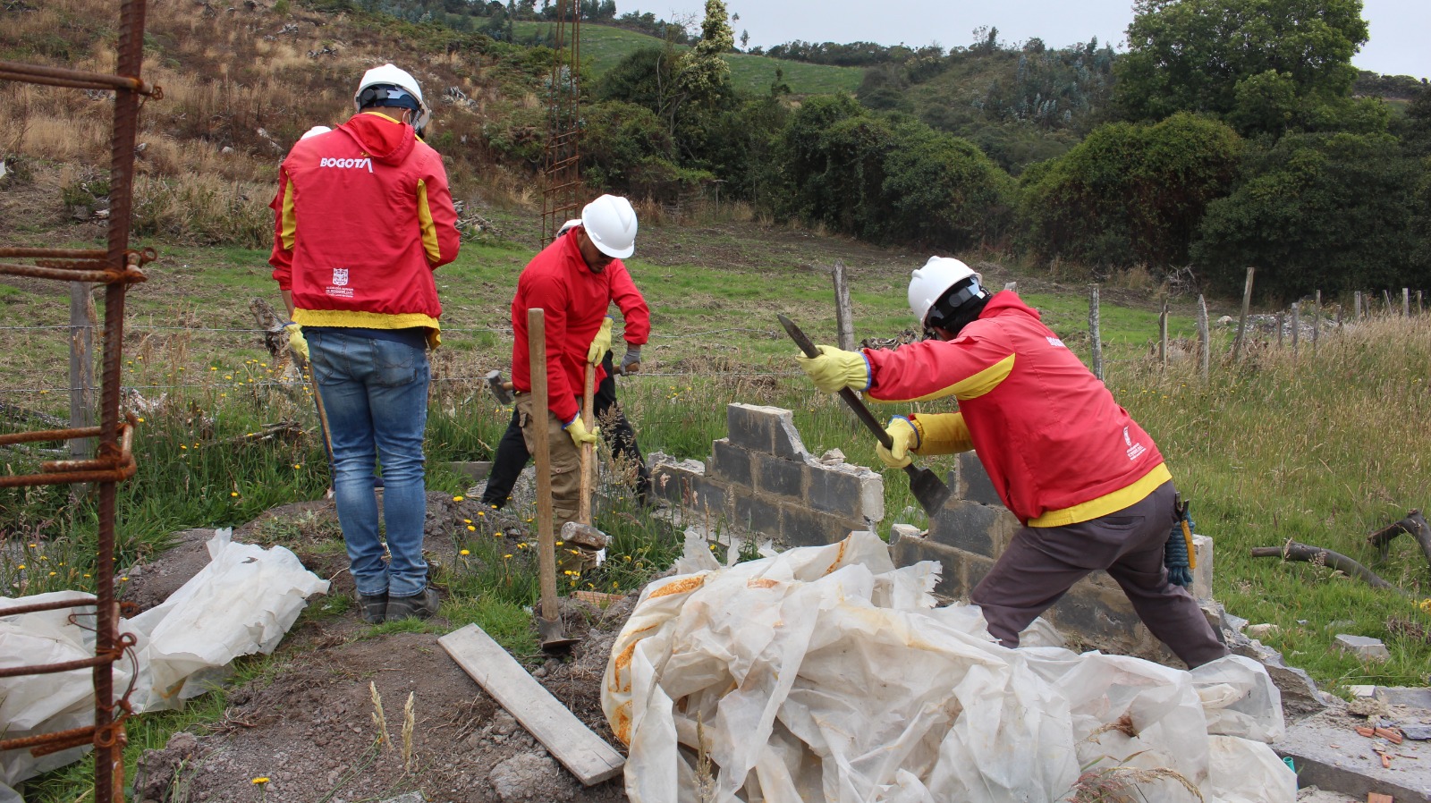 Tres hombre derribando un muro