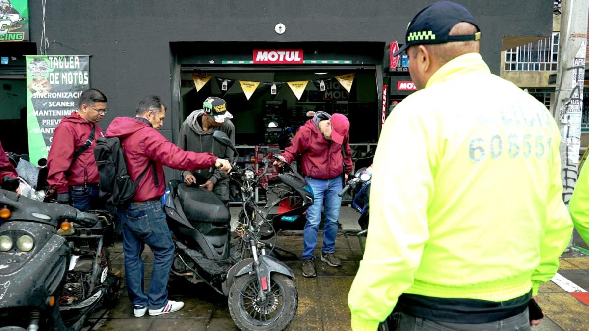 Funcionarios y Policía inspeccionando motocicletas