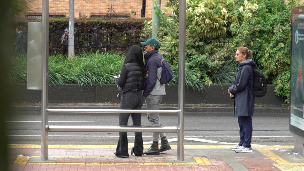 Hombre acosando a una mujer en el paradero del bus