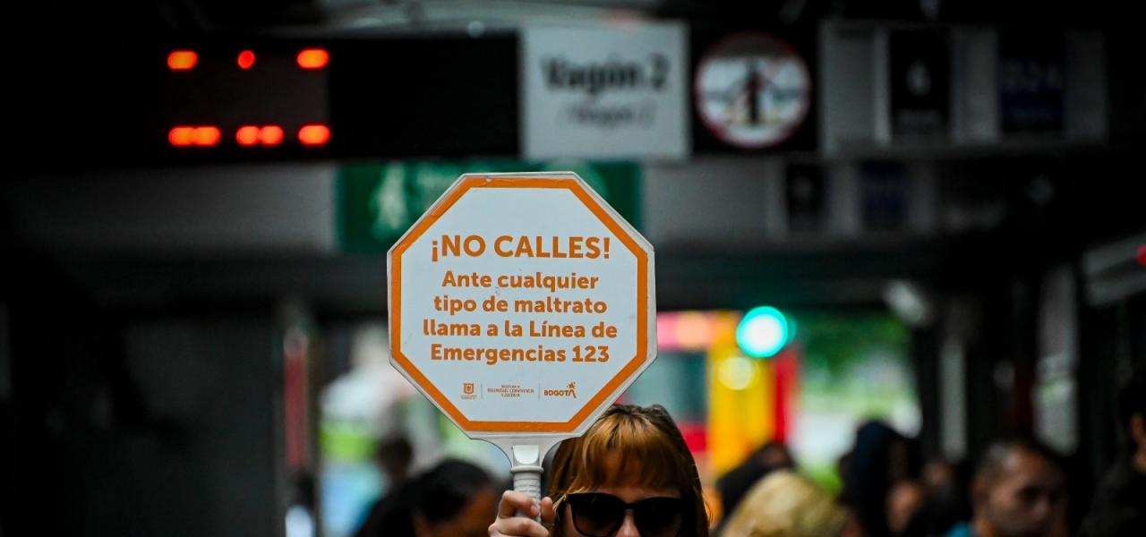 Pancarta mostrando la frase de no callar ante el acoso en Transmilenio.