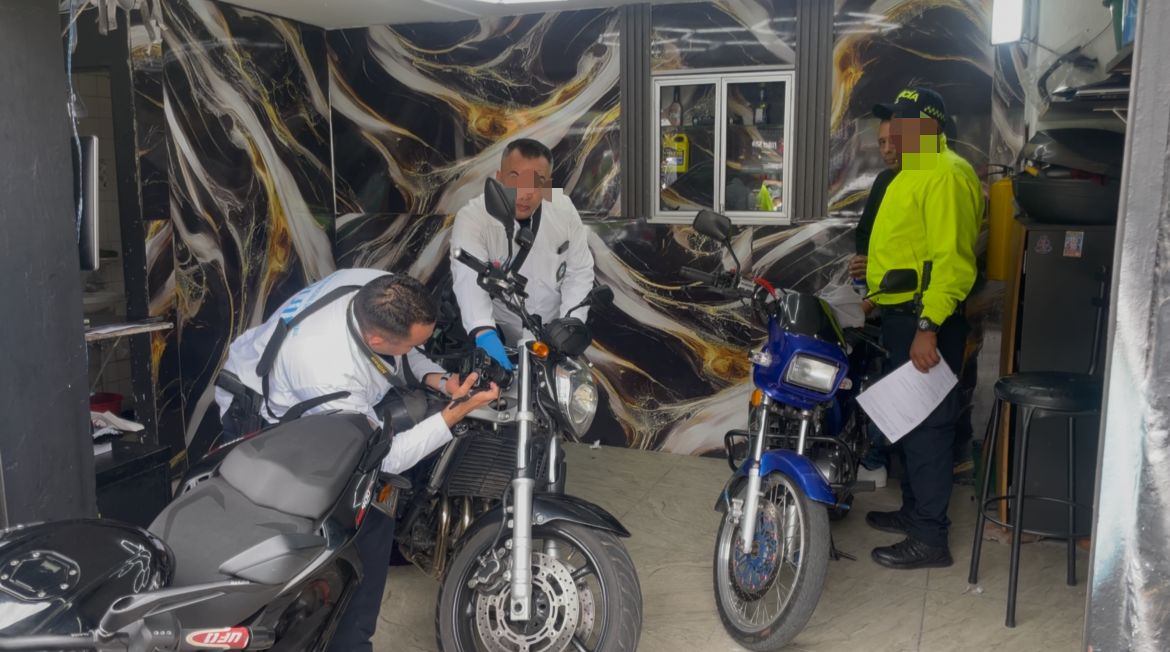 Cuatro hombres revisando dos motos