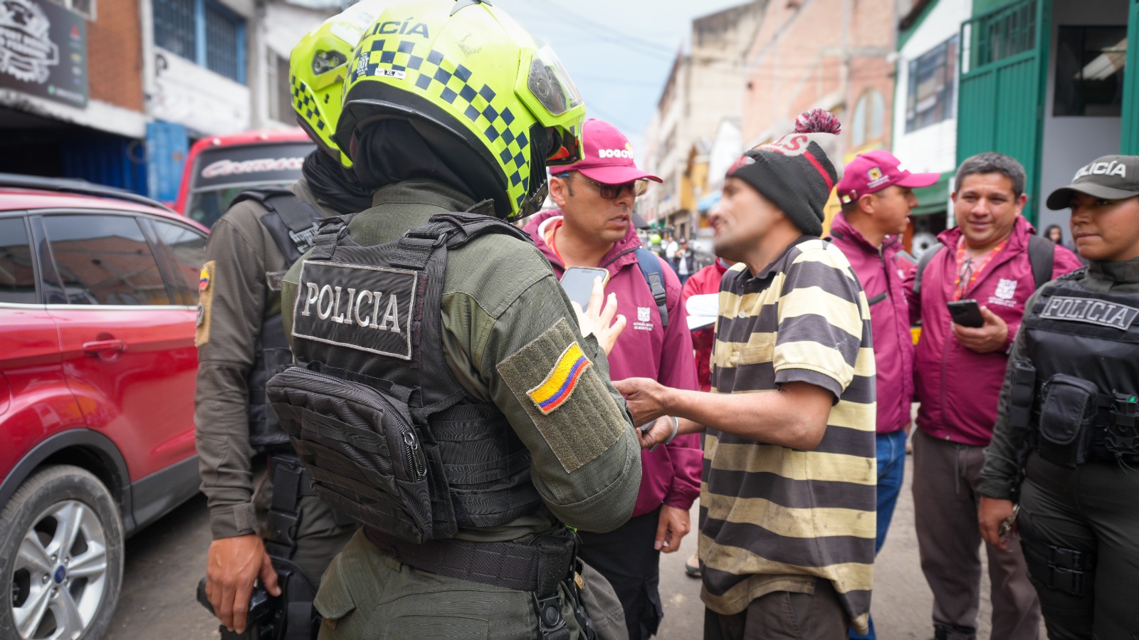 Varios hombres hablando con policías en una calle