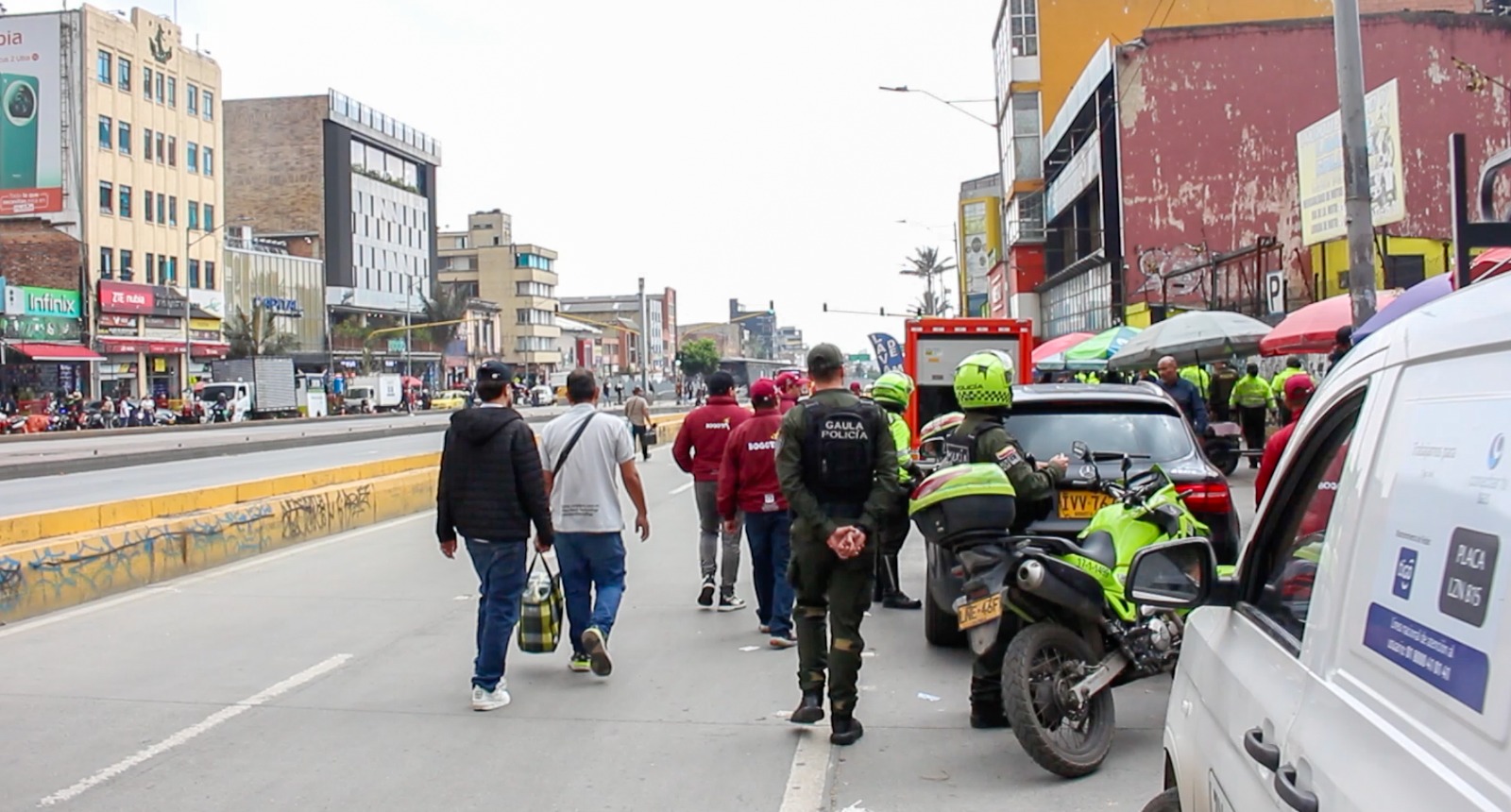 Hombres y policías caminando por la calle