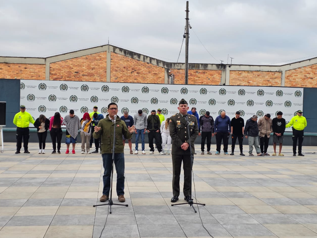 Policía y el Secretrario Cesar Restrepo hablando por micrófono