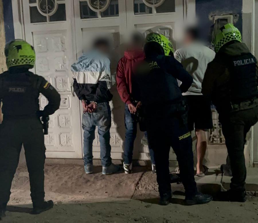 Tres hombres siendo capturados por tres policías