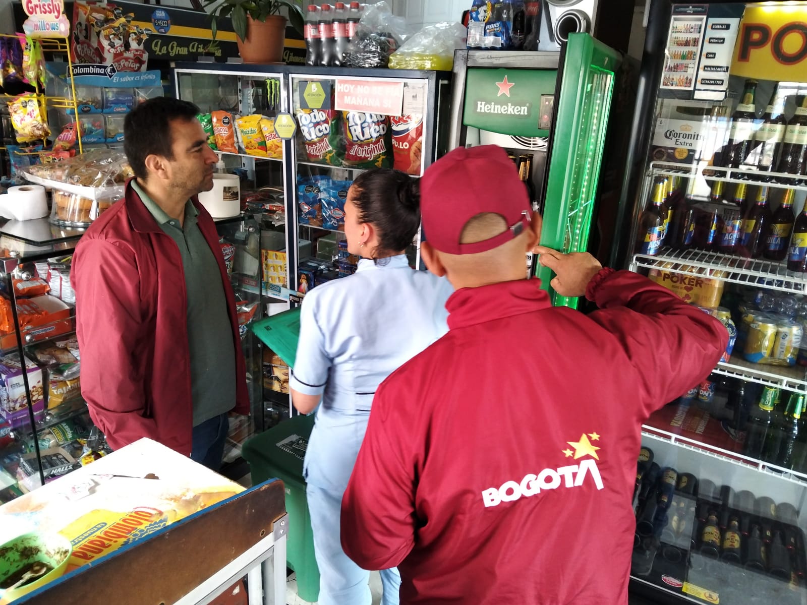 Dos hombres y una mujer hablando en una tienda