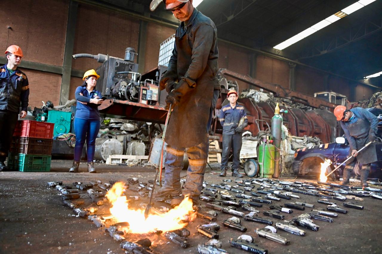 Pistolas traumáticas, cuchillos y tambos: así fueron destruidas más de 170 mil armas incautadas en Bogotá Hombres con varias armas en el piso para ser fundidas