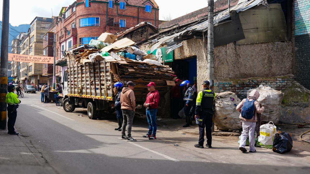 Varias personas en una calle y un camión con materiales