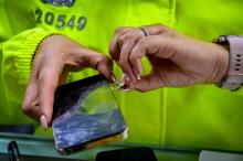 Policía sacando una sim card de un celular