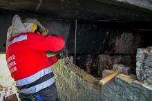 Un hombre cerrando un hueco de un puente