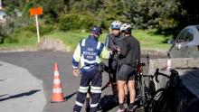 Un policía ayudando a dos ciclistas