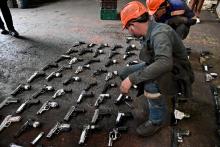 Hombre con armas próximas a destruir en el piso